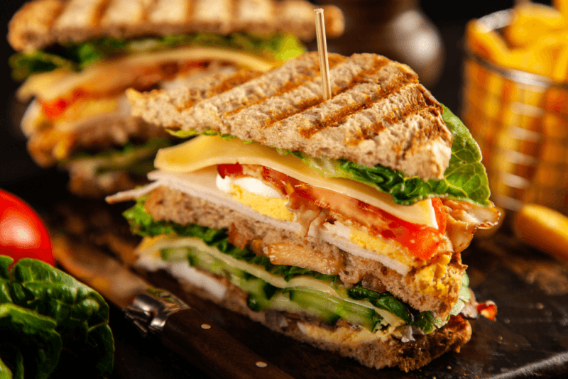 Two delicious breakfast club sandwiches with plenty of fillings.