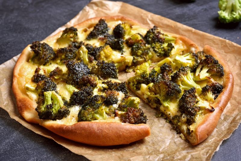 A broccoli pizza on a piece of paper