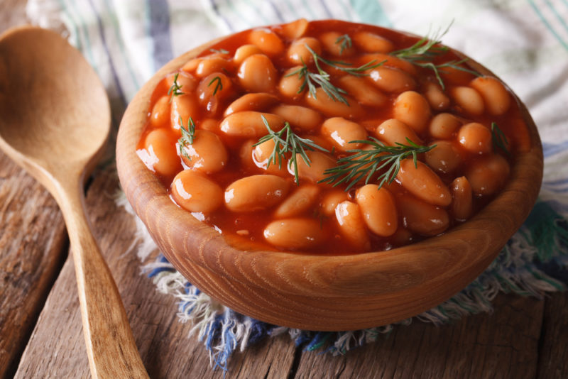 A brown bowl of cooked baked beans