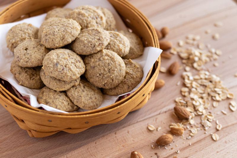 A basket of fresh cooked cookies on a wooden table