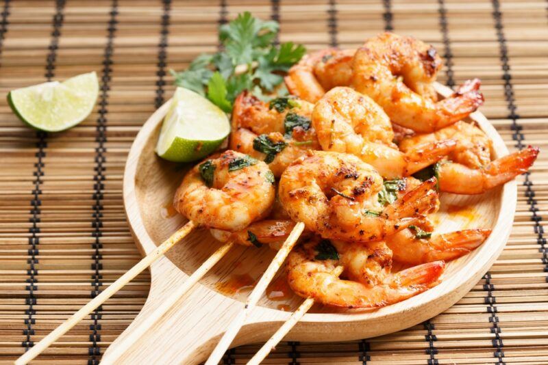 A light brown dish with shrimp on skewers