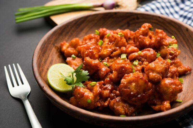 A brown dish containing butter chicken that has been made using cauliflower