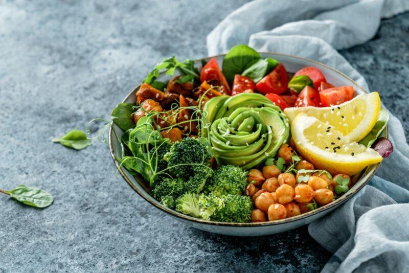 A large bowl containing plenty of alkaline ingredients, such as avocado, tomatoes, broccoli, and more