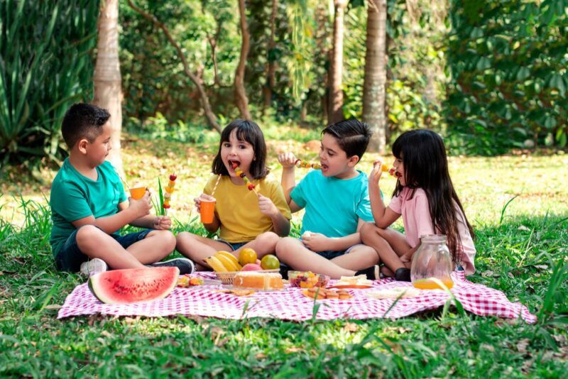 A bunch of kids having a picnic outside