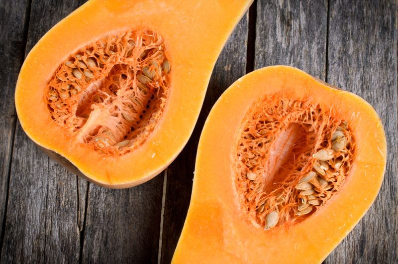 A sliced butternut squash on a wooden table