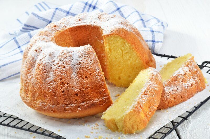 A white tray and a cake with powdered sugar on top