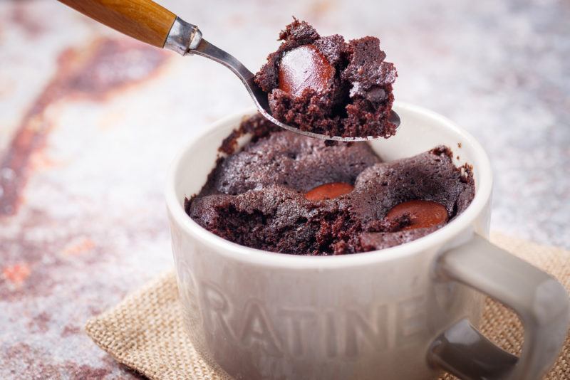 A chocolate mug cake being scooped out with a spoon