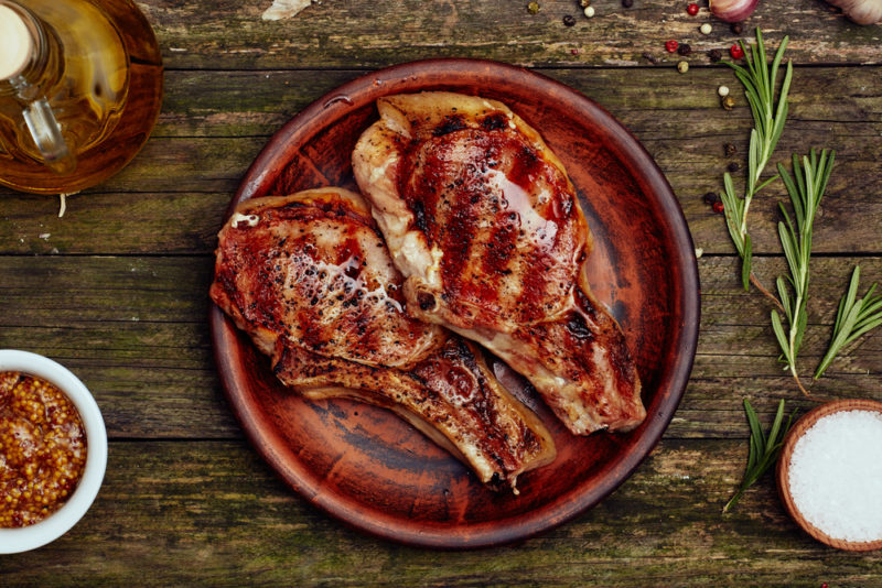 A red brown plate with two grilled pork chops