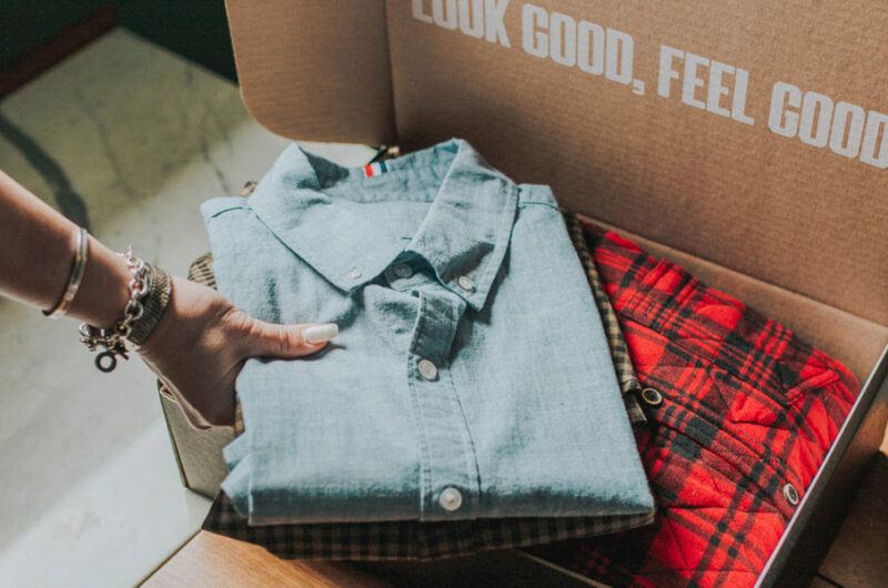 Someone unboxing clothing from Trendy Butler, showing shirt and text about feeling good