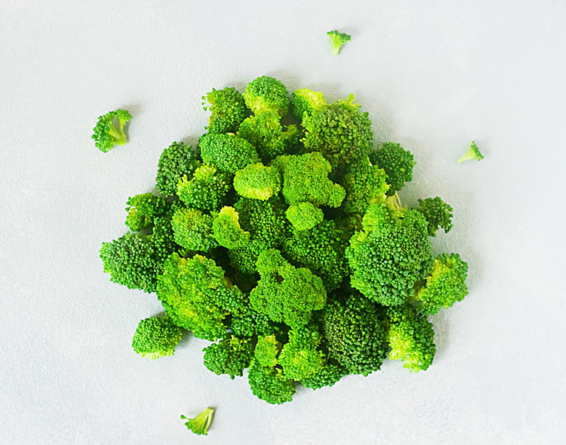 A clusber of bright green broccoli against a white background