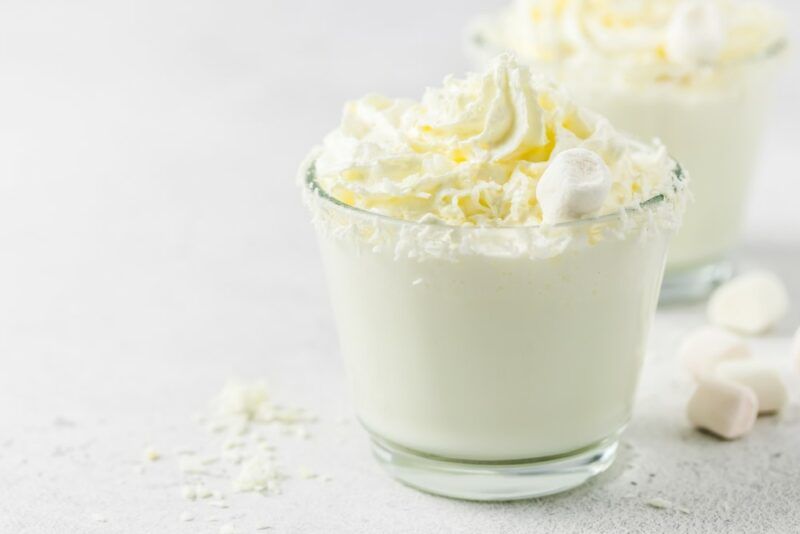 Two glasses of a white creamy cocktail, made using whipped cream vodka