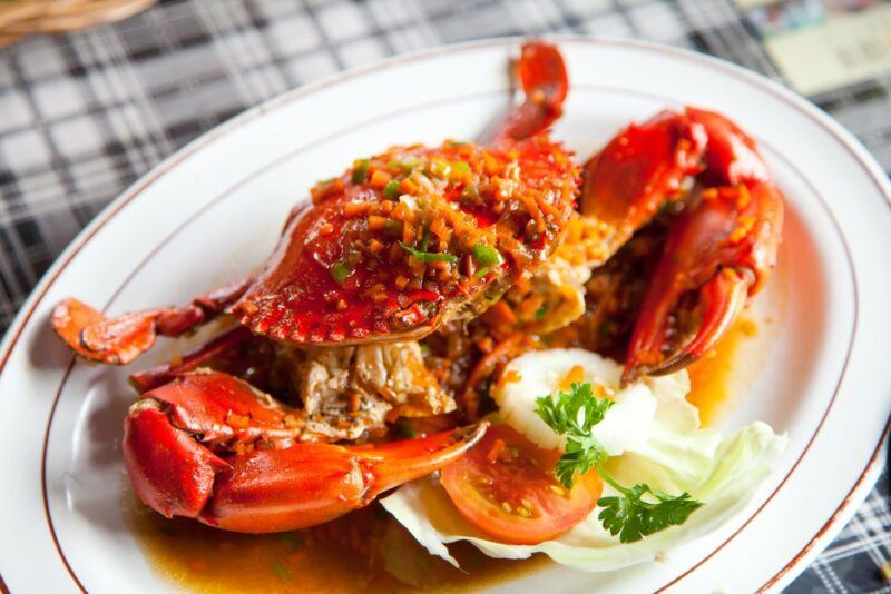 A white plate containing a cooked crab