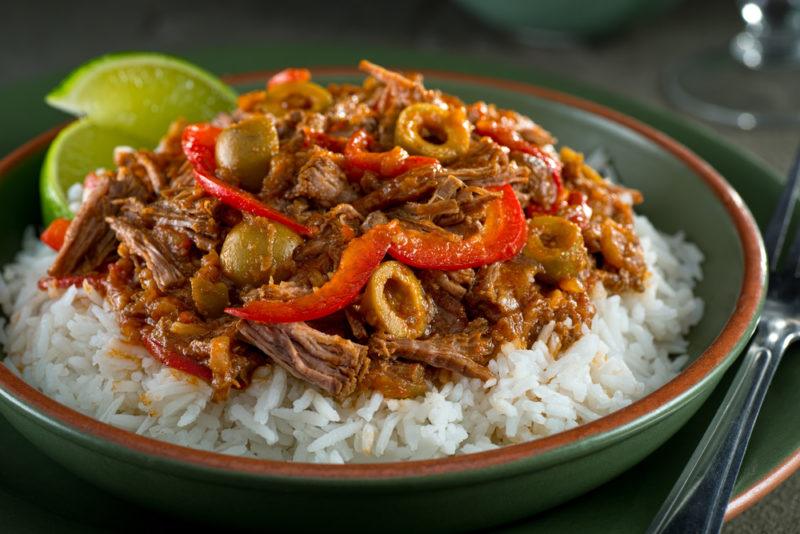 A green dish containing Ropa Vieja on rice