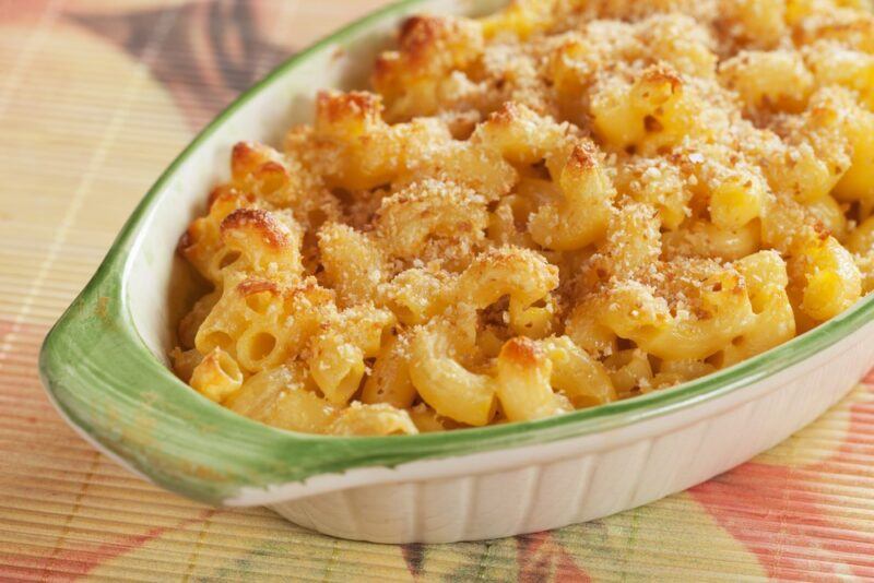 A green and white dish containing baked mac and cheese