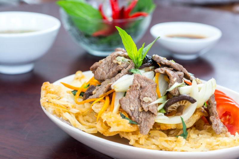 A shallow white bowl with a dish of fried pho xao