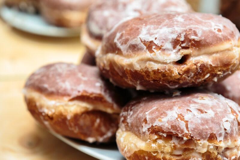 A blue plate with chocolate paczki donuts