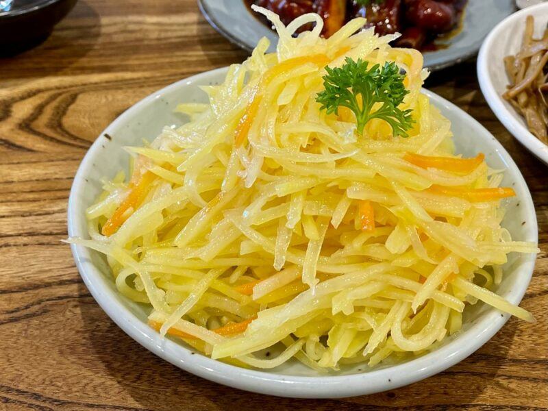 A small bowl containing a Chinese potato salad, made using raw potatoes