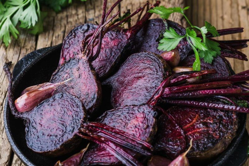 Roasted beets in a dish on a wooden table