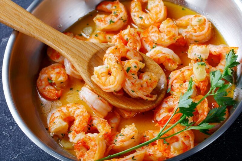 A stainless steel bowl containing shrimp scampi