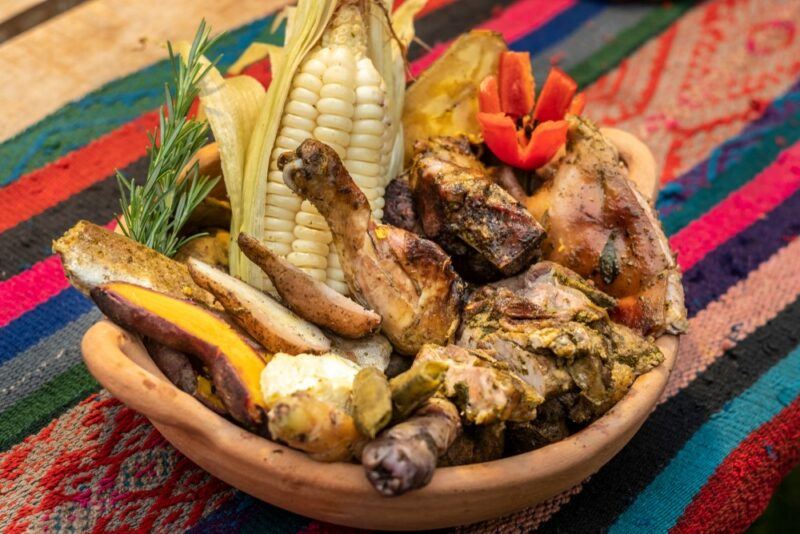 A small bowl overflowing with food called pachamanca