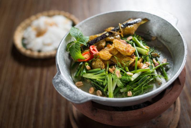 A gray dish with a turmeric fish meal called cha ca