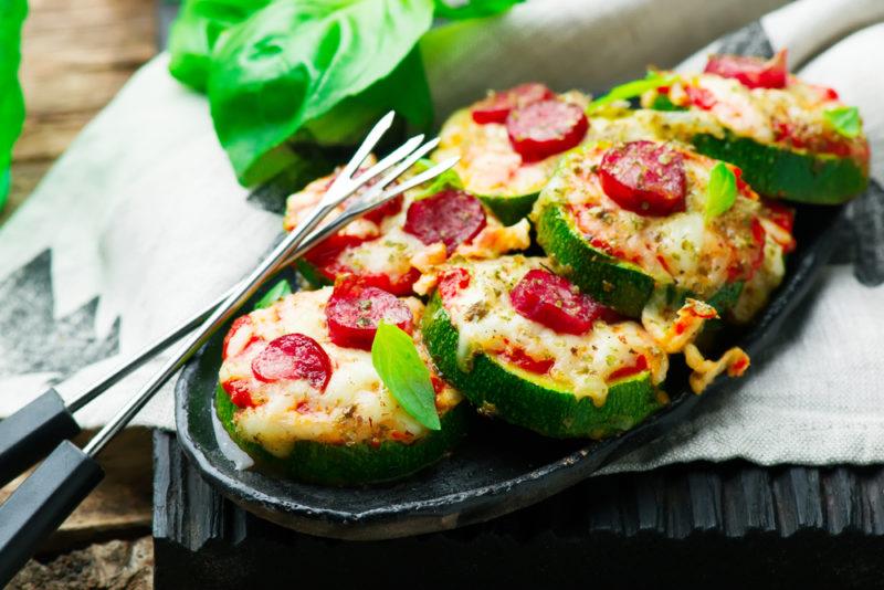 A oval dish with a zucchini pizza and two forks