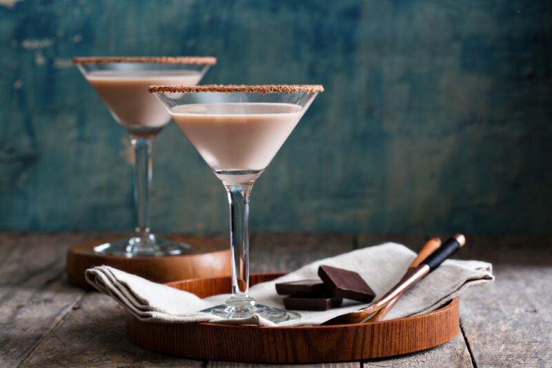 A tray with a single dulce de leche cocktail, with a second one on the table