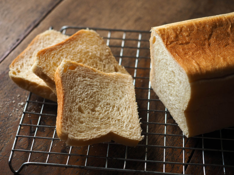 A fresh loaf of soft bread | Food For Net A fresh loaf of bread on a cooling rack with a few sliced pieces