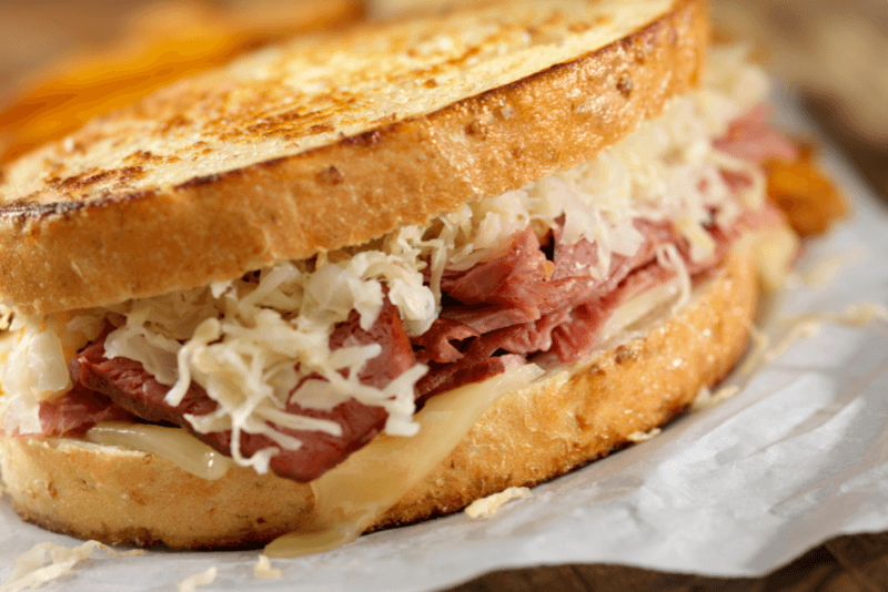 A freshly toasted reuben, complete with sauerkraut and corned beef.