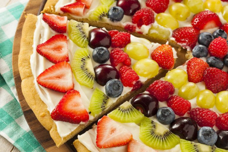 A fruit pizza with a white spread