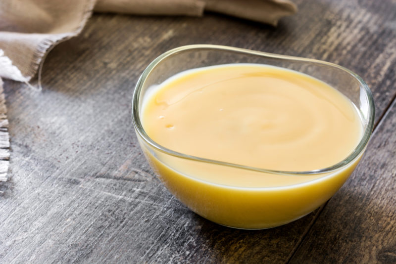 A glass bowl of custard on a wooden table