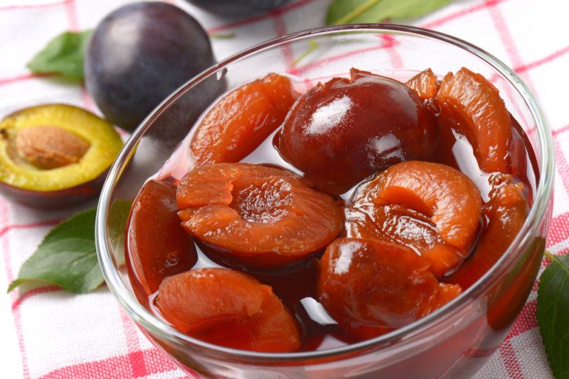 A glass bowl of stewed plums