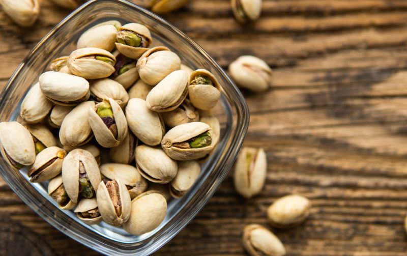 A glass jar with fresh pistachio nuts