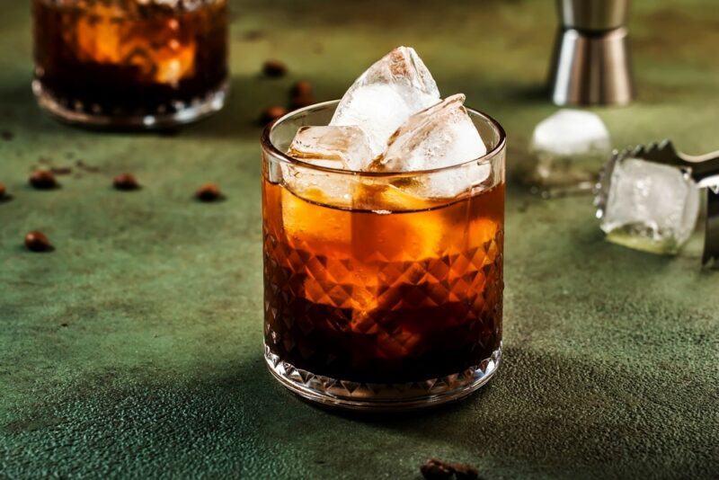 A glass containing a Guinness black Russian on a table with a second glass in the background