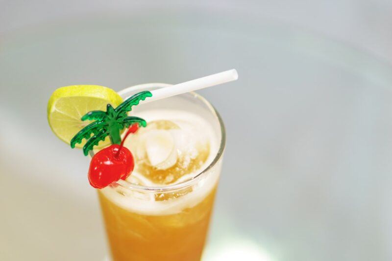 A glass containing a Scorpion cocktail garnish with a straw and citrus