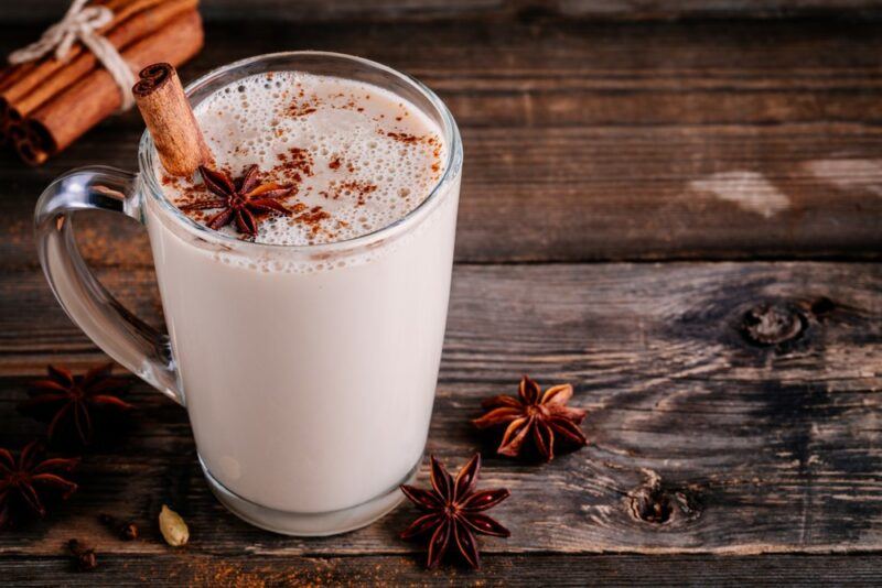 A glass of a chai tea latte on a wooden table