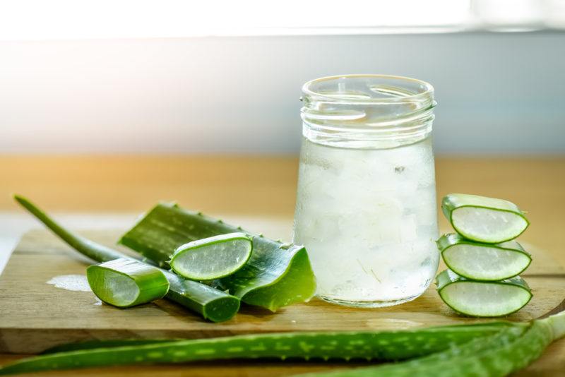 A glass of aloe juice with aloe vera cut up