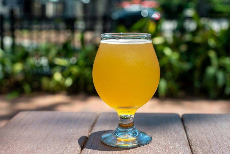 A wooden table with a glass of summer beer outside