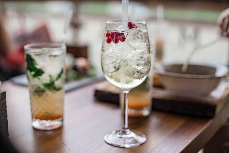 A wine class containing a lillet spritz cocktail, next to a regular glass containing a similar drink