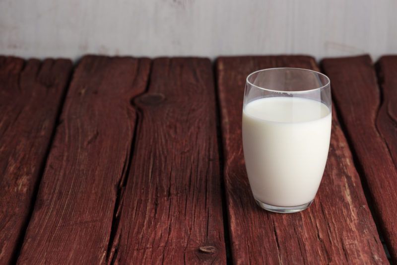 A glass of milk on a wooden table