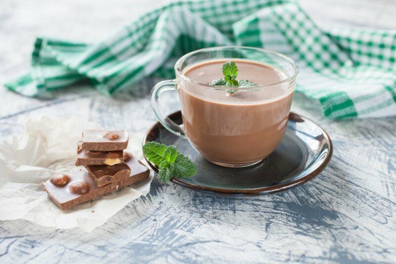 A plate and a glass mug of mint hot chocolate