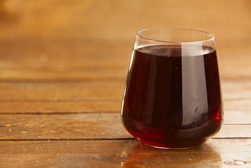 A glass of prune juice on a wooden table