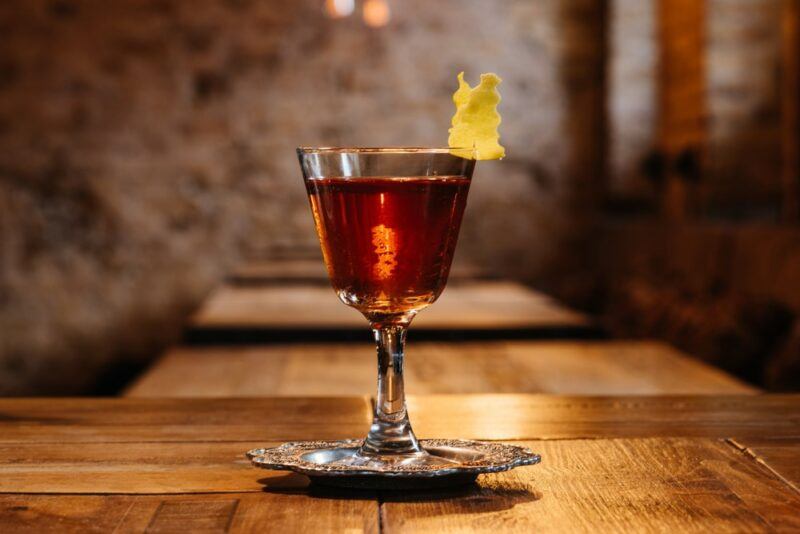 A glass of sazerac on a wooden bar