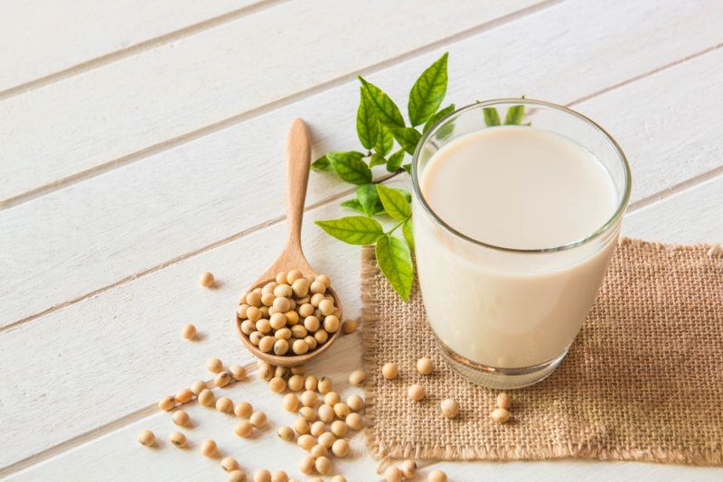 A glass of soy milk with a spoon of soybeans