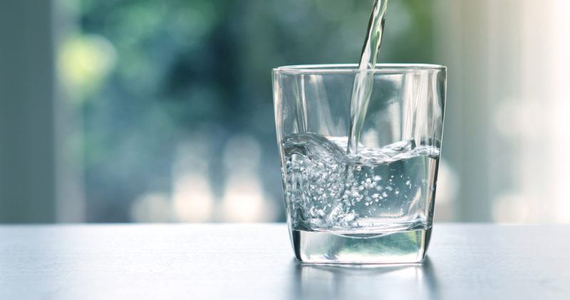 A glass of water being poured from above