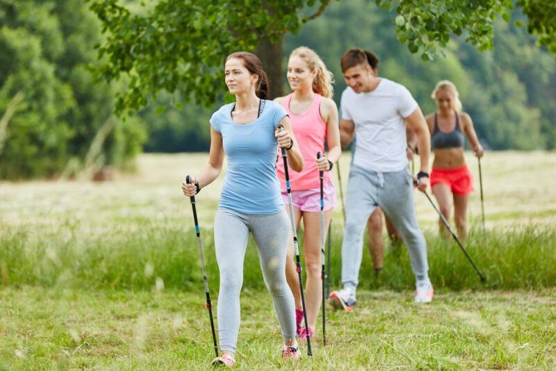 A group of peole walking outdoors using Nordic poles