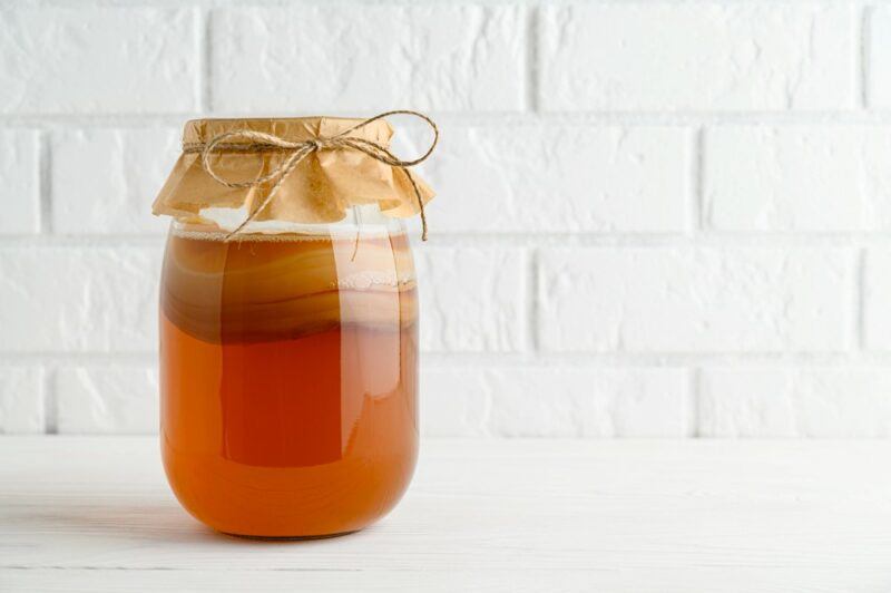 A large jar of kombucha with the SCOBY growing in it