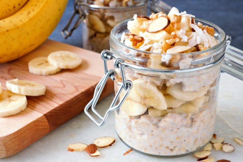 A glass jar with overnight oats, including bananas and syrup