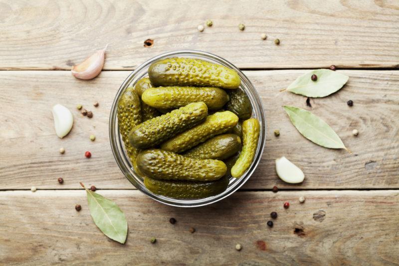 A jar of pickled cucumbers on a wooden table