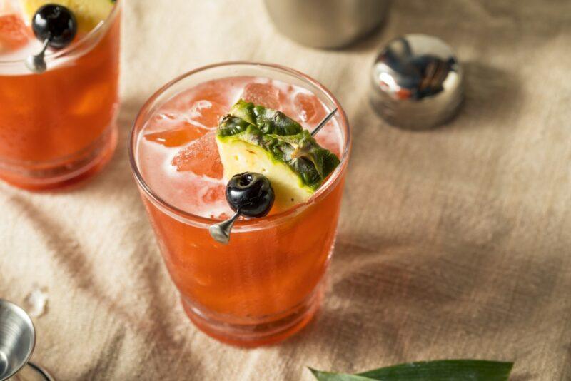 Two glasses containing a red jungle bird cocktail